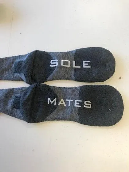 Two gray socks laid side by side, labeled "SOLE" on one and "MATES" on the other.