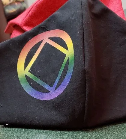 Black face mask with a rainbow-colored square and circle design printed on one side.