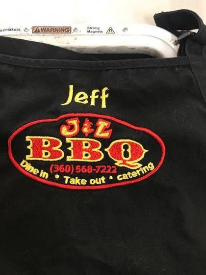 Black apron with "Jeff" and the J&L BBQ logo, including "Dine in • Take out • Catering" and a phone number.