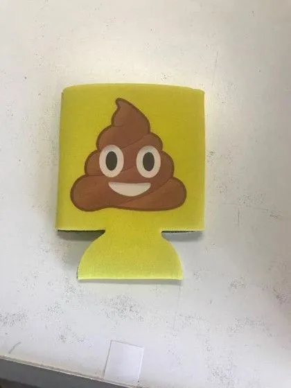 A yellow can holder with a smiling poop emoji design on a white surface.