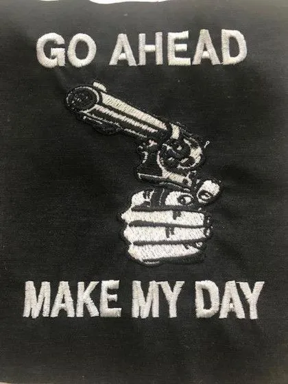 The image shows a hand holding a revolver with the text "GO AHEAD MAKE MY DAY" above and below the gun.