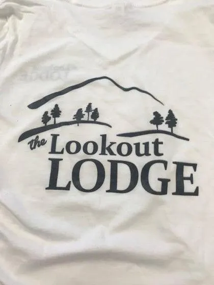 White shirt with "the Lookout LODGE" text and a graphic of trees and a mountain in black print.
