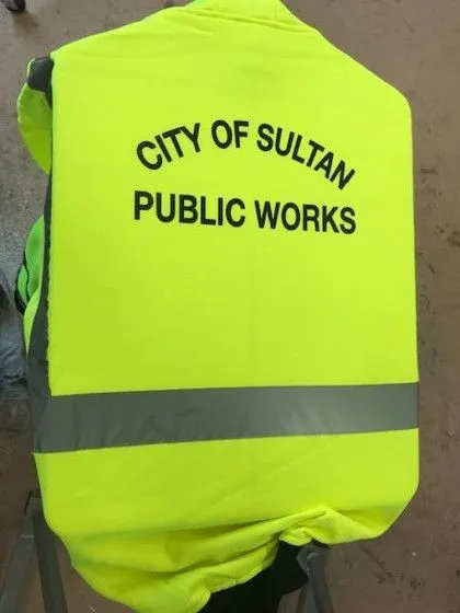 A high-visibility vest with "City of Sultan Public Works" printed on the back.