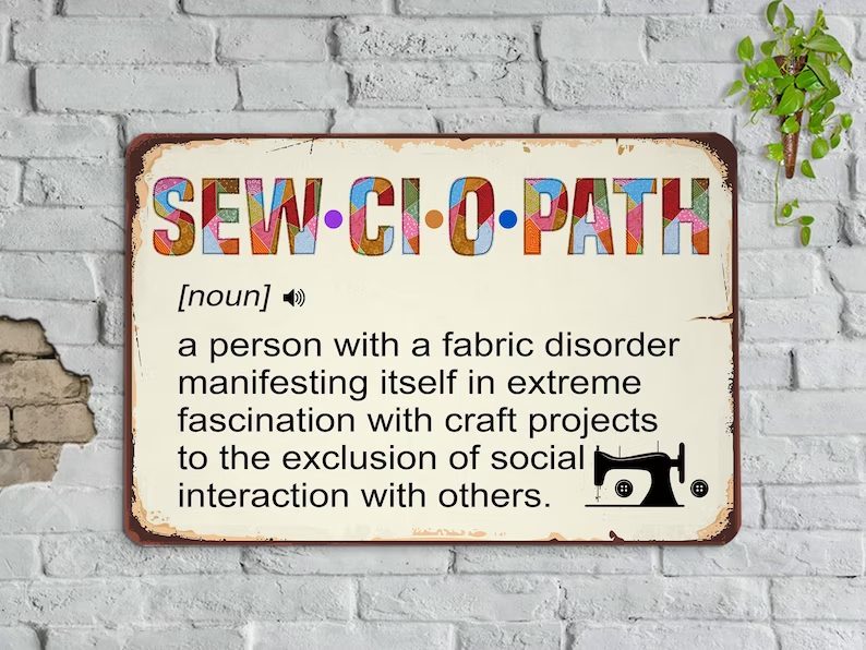 A sign reads: "SEW-CIOPATH [noun] a person obsessed with craft projects, avoiding social interaction.