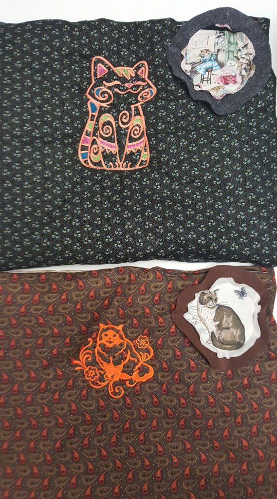 Two pieces of patterned fabric with cat embroidery and fabric patches featuring printed cat illustrations.